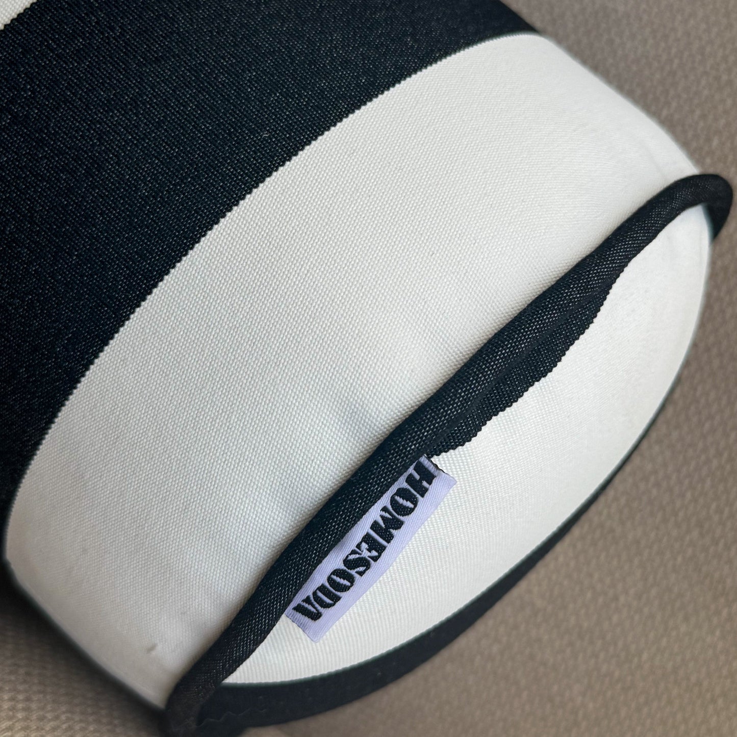 Black and white visor with 'HOMESODA' label on a beige background